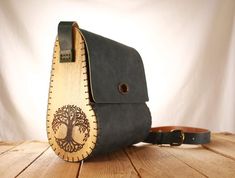 a wooden bag sitting on top of a wooden table next to a leather belt strap