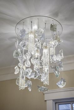 a crystal chandelier hanging from the ceiling in a room with white walls and ceilings