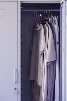 an open locker with clothes hanging on hangers