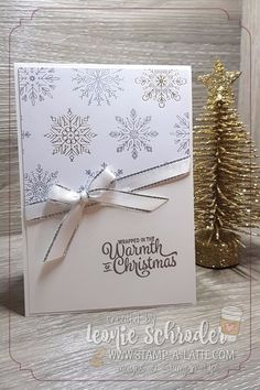 a christmas card with snowflakes on it and a gold pine tree in the background