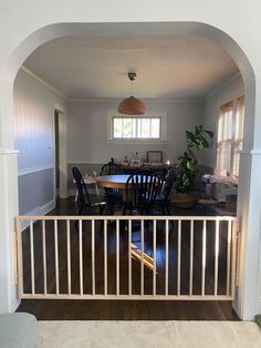 an archway leading into a dining room and kitchen area with table and chairs in it