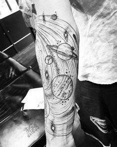 a man with a tattoo on his arm that has an image of the solar system