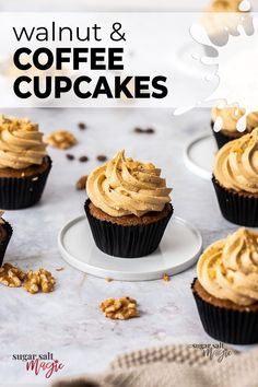 several cupcakes with frosting and walnuts on top sitting on a table