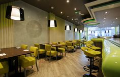 the interior of a restaurant with yellow chairs