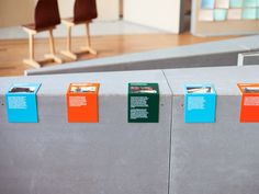 there are some chairs and signs on the concrete wall in this museum display area,