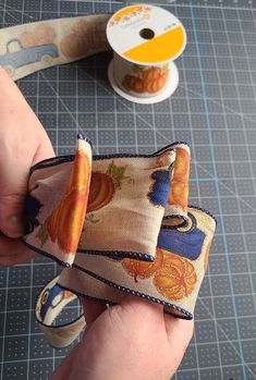 a person is holding a ribbon in their hand and some scissors are on the table