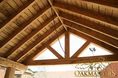 the inside of a building with wooden roofing and beams on it's sides