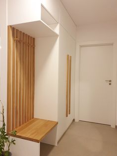 an empty room with wooden slats on the wall and a plant next to it