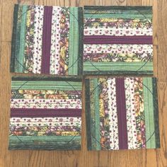 four quilted coasters sitting on top of a wooden table