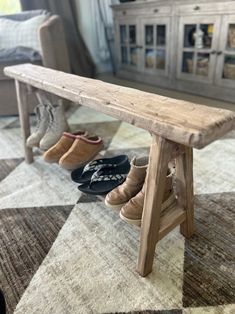 two pairs of shoes are sitting on a bench in front of a couch and coffee table