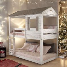 a white bunk bed sitting next to a christmas tree in a room with lights on the walls