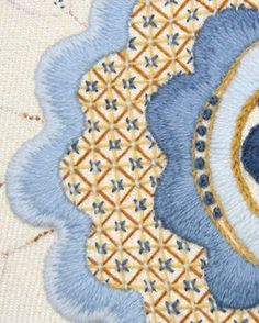 a close up view of a piece of art with blue and yellow designs on it