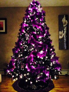 a purple christmas tree with white lights in a living room