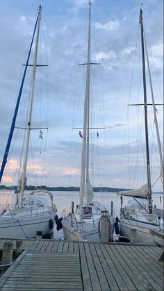 several sailboats docked at a pier on the water