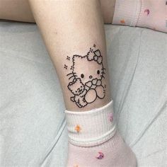 a person with a hello kitty tattoo on their leg