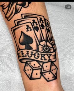 a black and white tattoo on the leg of a man's arm with playing cards