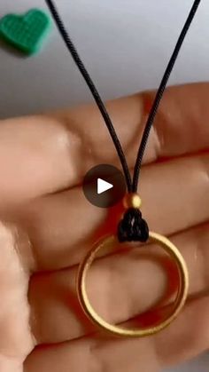 a person holding a gold ring necklace in their hand