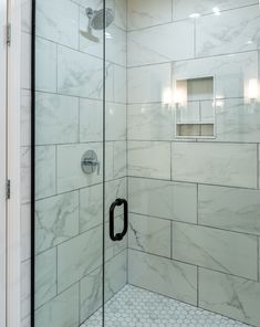 a walk in shower sitting next to a white tiled wall and floor with black trim