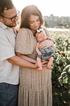 a man and woman holding a baby in their arms