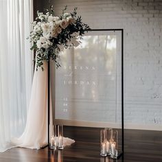 a table with candles and flowers on it next to a large sign that says the wedding date