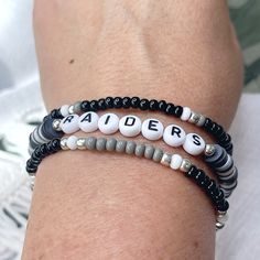 🏈 Who loves football? Who loves the Las Vegas Raiders? Show your team spirit with this fun bracelet set! Great for gift giving!! Lightweight and oh so comfy to wear. You will receive 3 bracelets that are made on strong stretch cord and made to fit a 7 1/2" wrist. Need a different size? Just let me know your wrist size and I will be happy to custom make for you! Each piece is handmade with: - High Quality Glass Seed Beads - Silver High Quality Seed Beads that won't tarnish* - Heishi Vinyl Beads - White/Black Acrylic Letter Beads - Stretch Cord: high-quality cord with reinforced knots Easily layer with other Luna by Rachel bracelets for a stunning stack! My pieces are made sturdy, but as with all jewelry, they are also delicate and should be treated with care. Be sure to check out other des Sports Team Beaded Bracelets, Game Day Black Wristband With Letter Beads, Black Adjustable Beaded Bracelets Team Spirit Style, Black Team Spirit Adjustable Beaded Bracelets, Black Adjustable Beaded Bracelets For Team Spirit, White Beaded Bracelets For Football Season, Personalized White Beaded Bracelets For Football Season, Black Beaded Bracelets With Letter Beads For Game Day, Team Spirit Beaded Bracelets For Game Day