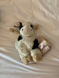 a stuffed cow laying on top of a bed