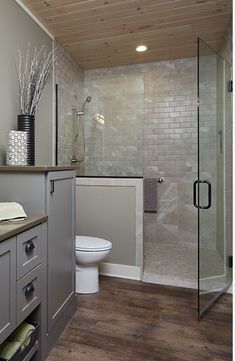 a bathroom with a toilet, sink and shower stall is shown in this image from the front view