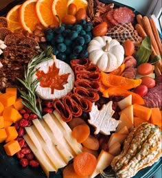 a platter filled with cheeses, fruits and vegetables