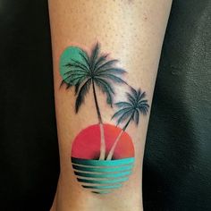 a woman's foot with a palm tree and sunset tattoo on the side of her leg