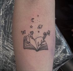 an open book with butterflies flying out of it and stars coming out of the pages