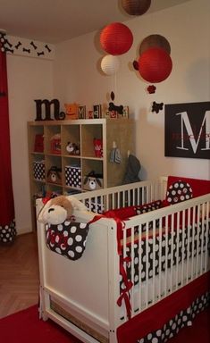 a baby's room decorated in red, white and black