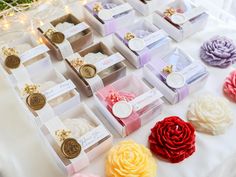 many different types of soaps and flowers on a table with lights in the background