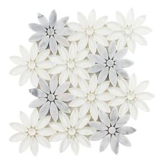 white and grey flowers are arranged on a white surface