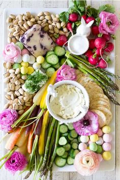 a platter filled with different types of vegetables and dips on top of each other