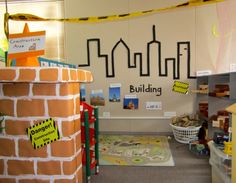 an office with a brick wall and yellow tape on the walls that says building in front of it