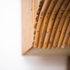 a close up view of bamboo sticks in a wooden box with holes on the side