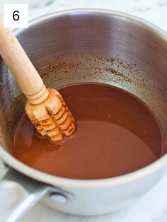 a wooden spoon stirring chocolate in a pot