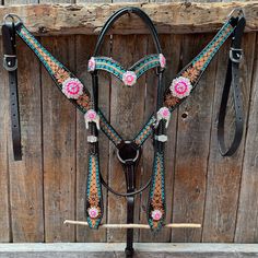 a horse bridle with pink flowers on it's head and matching reins