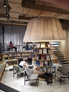 a library filled with lots of books and people sitting at tables next to each other