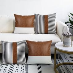 a white couch with brown and black pillows on it