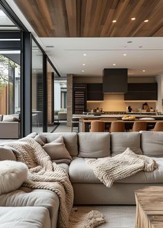 a living room filled with furniture next to a kitchen and dining room table in front of an open floor plan