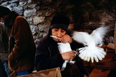 a man holding a white bird in his hand