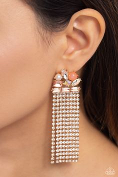 Featuring pronged gold fittings, a trio of peachy emerald-cut gems lay across the ear in a horizontal manner. Various peachy, white, and iridescent gems and a milky orange bead and white pearl haphazardly cluster up the ear from the horizontal layer for additional eye-catching detail. Strands of white rhinestones in sleek gold square fittings cascade from the emerald-cut layer, creating freefalling glitzy movement. Earring attaches to a standard post fitting. Sold as one pair of post earrings. Blue Emerald, Latest Jewellery Trends, Paparazzi Accessories, White Necklace, Blue Gems, Earring Crafts, Latest Jewellery, White Rhinestone, Colourful Necklace