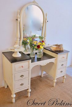 an antique vanity with flowers and vases on top