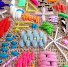 there are many different types of yarns and needles on the tablecloth with scissors