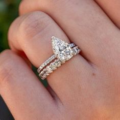 a woman's hand with a diamond ring on it and two bands around the band