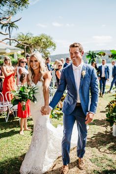 a bride and groom walking down the aisle after their wedding ceremony at an outdoor venue