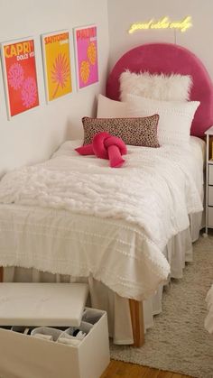 a white bed sitting next to a pink headboard