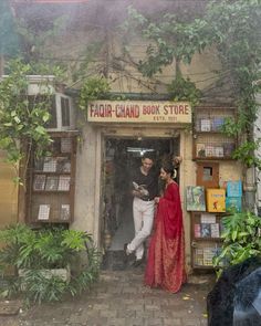 two people standing in front of a book store