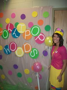 a woman standing in front of a wall with balloons